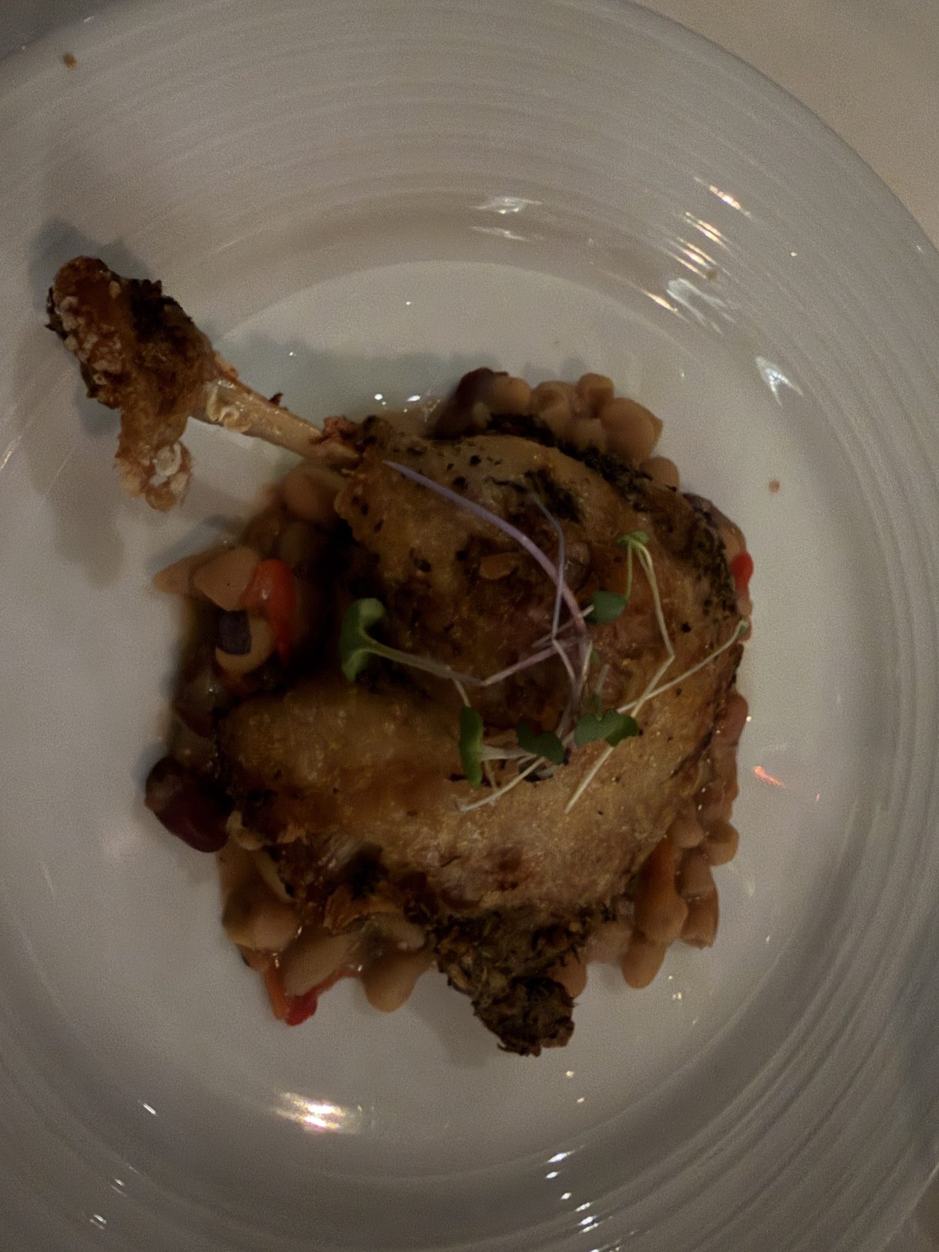 Confit duck leg on cannellini beans with peppers