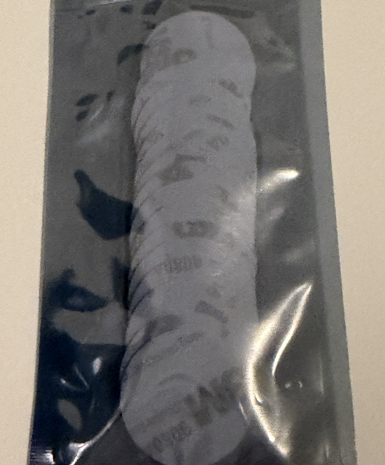 Stack of white NFC stickers in a clear sleeve, 3M adhesive showing through the back