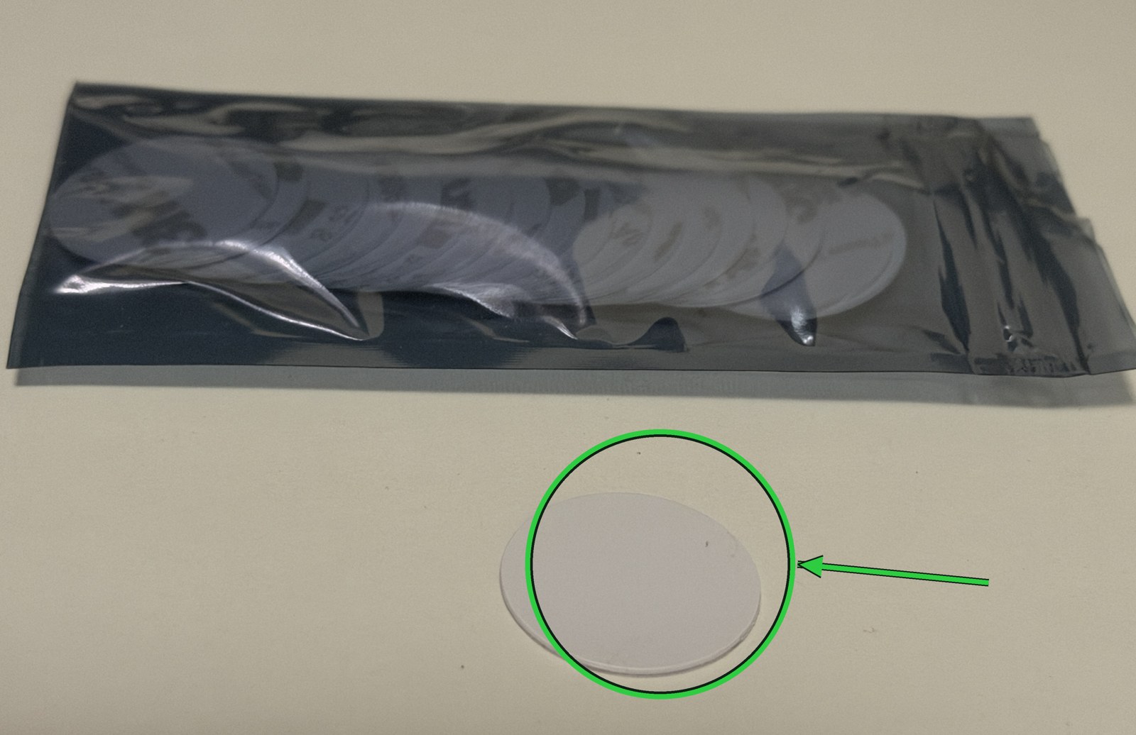 Pack of white round NFC stickers with one tag sitting outside the bag