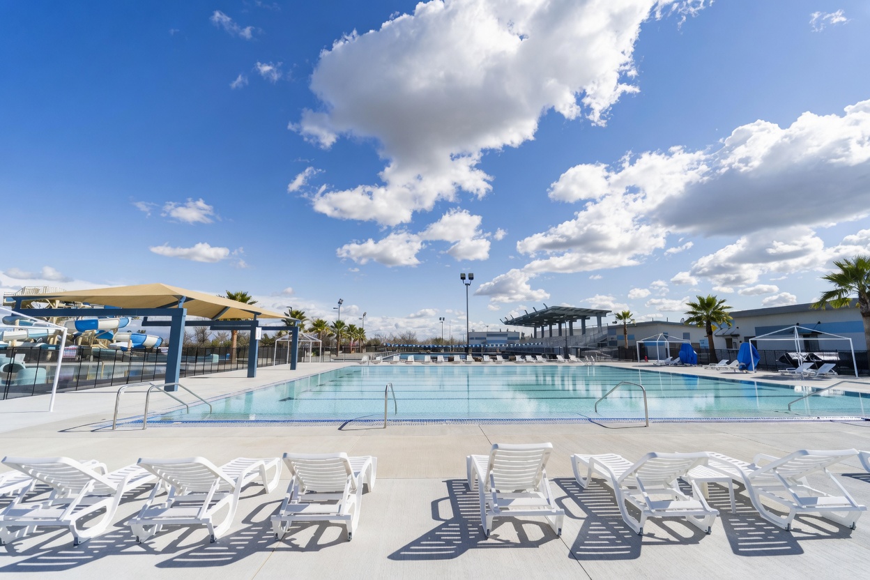 North Natomas–style outdoor aquatic complex with competition pool, shade canopy, and water slides