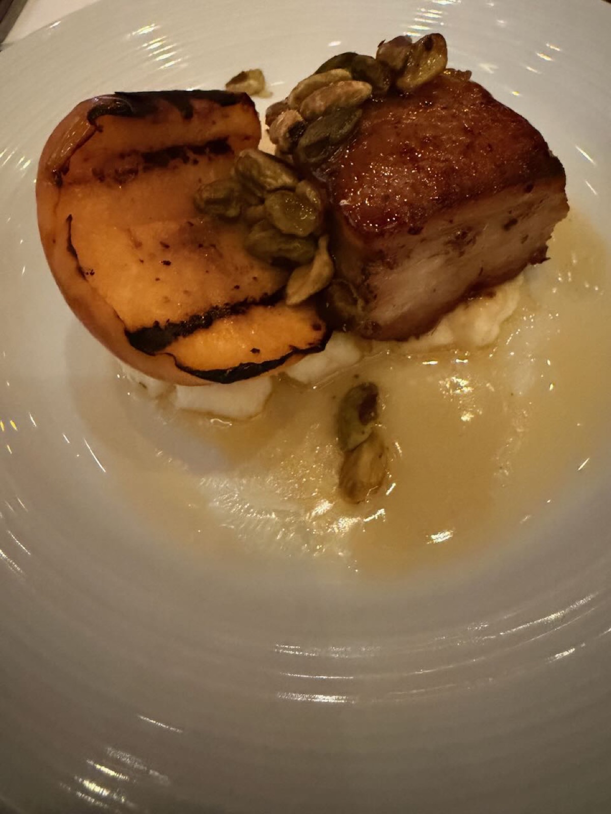 Crispy pork belly with grilled peach and pistachios